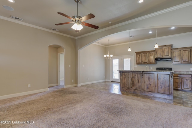5207 Jarvis St, Lubbock, TX 79416 - kitchen with under cabinet range hood, arched walkways, baseboards, brown cabinetry, and recessed lighting