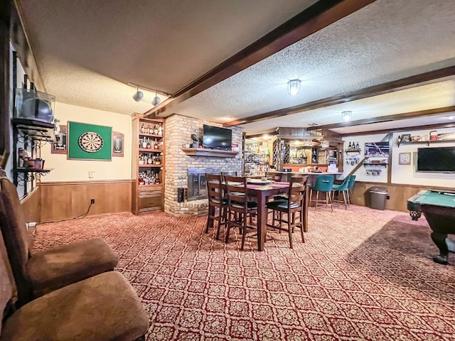 carpeted dining space with billiards, a textured ceiling, and wood walls