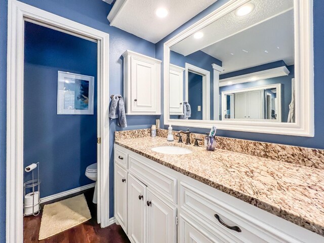 bathroom featuring hardwood / wood-style flooring, vanity, and toilet