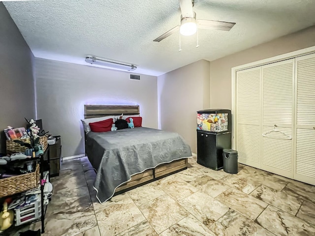 bedroom featuring ceiling fan, a textured ceiling, and a closet