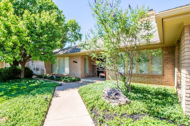 property entrance featuring a lawn