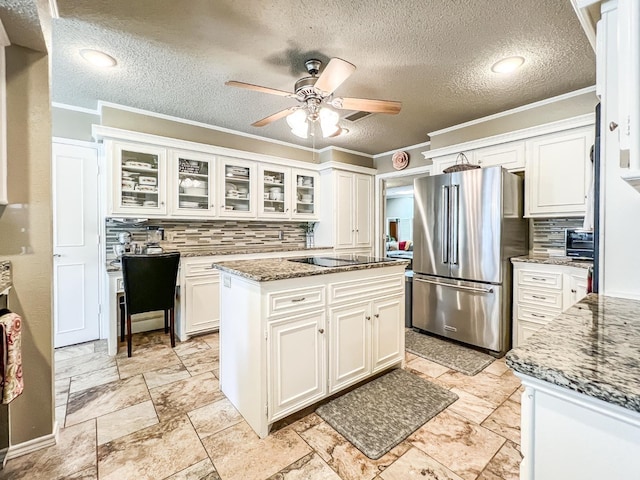 kitchen featuring white cabinetry, stainless steel fridge, and a kitchen island