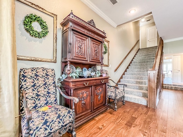 stairway featuring crown molding and wood-type flooring