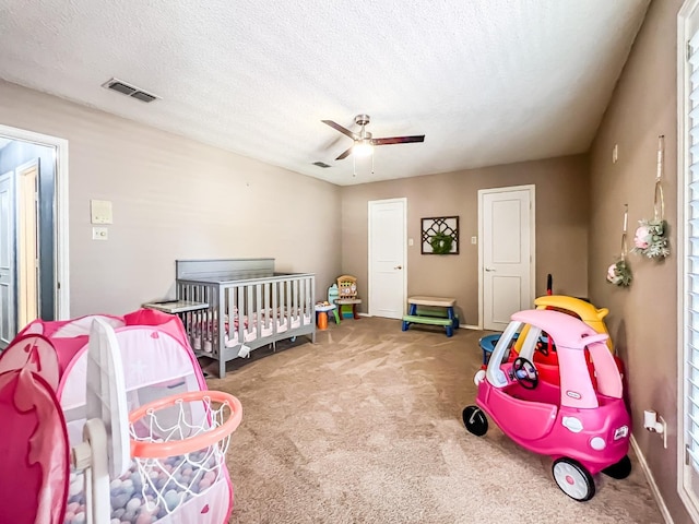 carpeted bedroom featuring ceiling fan and a textured ceiling