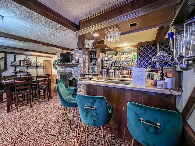 bar with beamed ceiling, a fireplace, and a textured ceiling