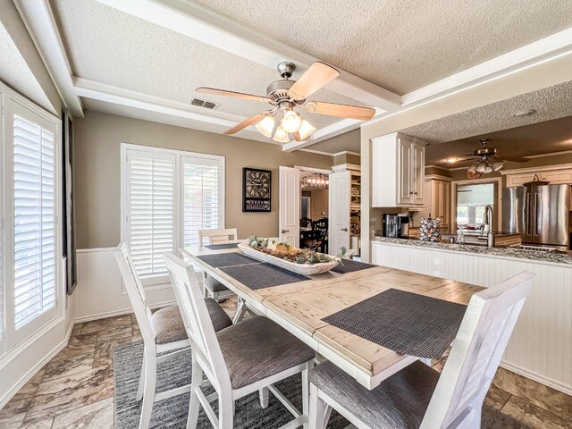 dining space with ceiling fan and a textured ceiling