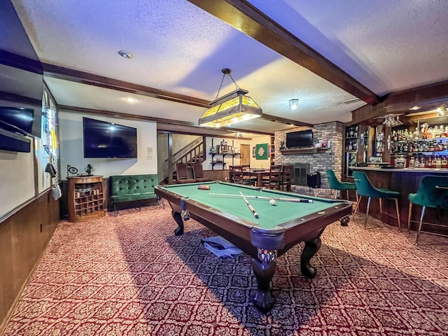 playroom with wooden walls, beam ceiling, pool table, bar, and a textured ceiling