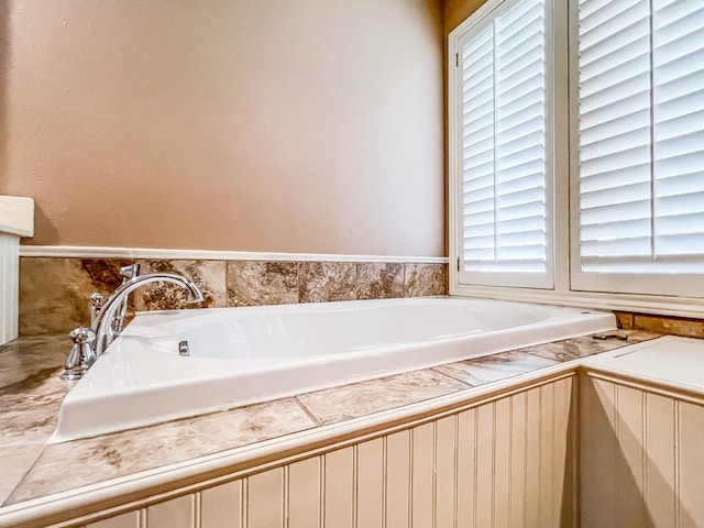 bathroom with a relaxing tiled tub