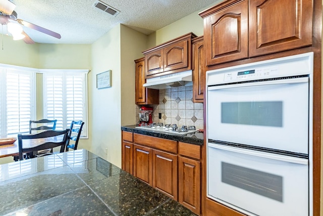 4306 Alcove Ave, Lubbock, TX 79407 - kitchen featuring visible vents, ceiling fan, white appliances, under cabinet range hood, and decorative backsplash