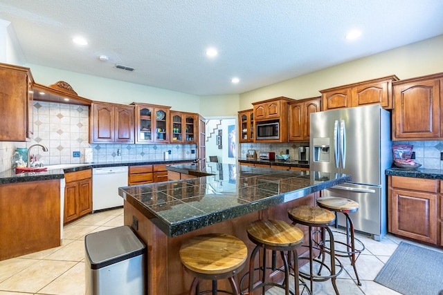 4306 Alcove Ave, Lubbock, TX 79407 - kitchen featuring light tile patterned floors, visible vents, a sink, backsplash, and stainless steel appliances
