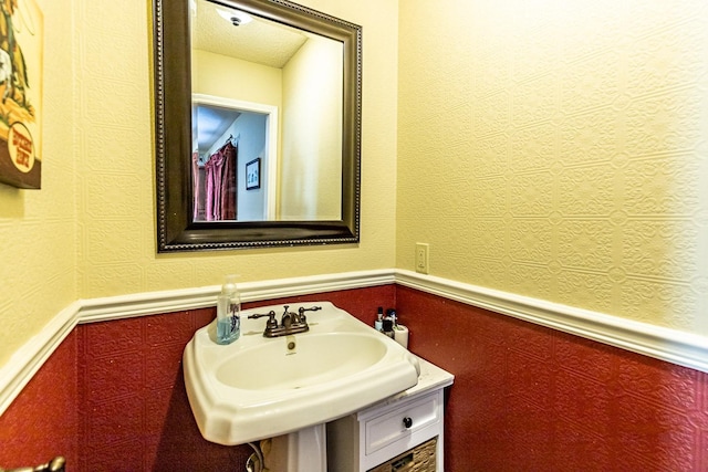 4306 Alcove Ave, Lubbock, TX 79407 - bathroom with a wainscoted wall, a sink, and a textured wall