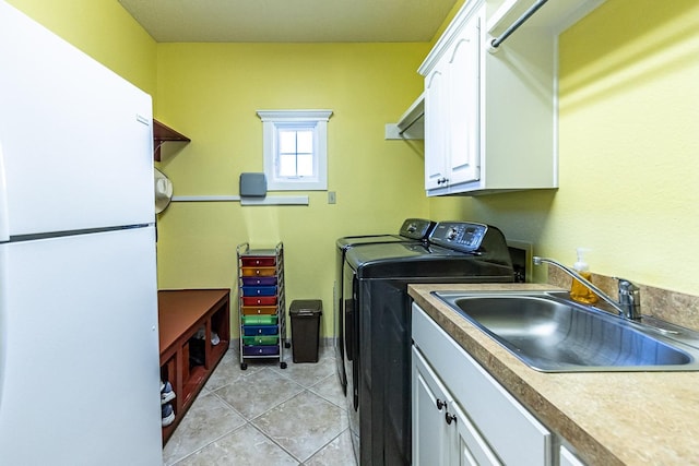 4306 Alcove Ave, Lubbock, TX 79407 - clothes washing area featuring cabinet space, independent washer and dryer, light tile patterned flooring, and a sink