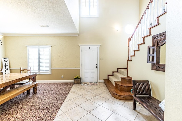 4306 Alcove Ave, Lubbock, TX 79407 - foyer with crown molding, plenty of natural light, light tile patterned floors, and stairs