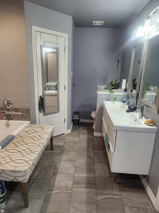 bathroom featuring vanity, toilet, and a bathing tub