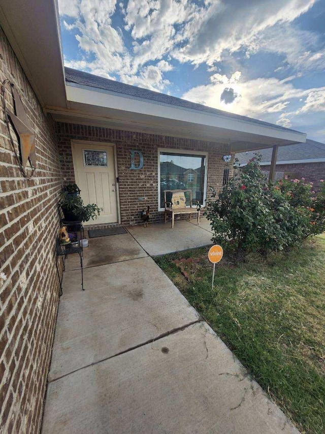 view of exterior entry featuring a patio area