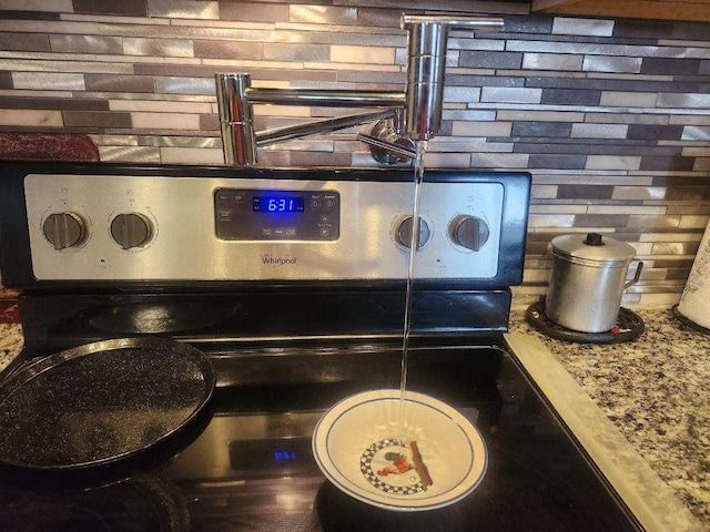 interior details with stainless steel electric range oven, backsplash, and light stone counters