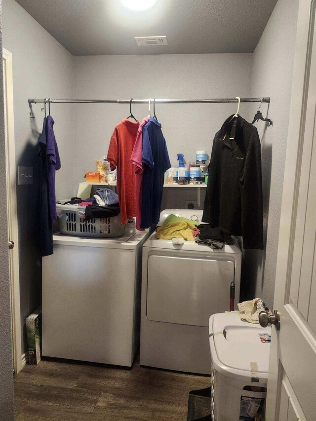 clothes washing area featuring hardwood / wood-style floors and washing machine and clothes dryer