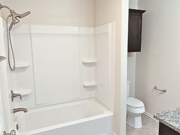 full bathroom featuring washtub / shower combination, vanity, toilet, and tile patterned floors