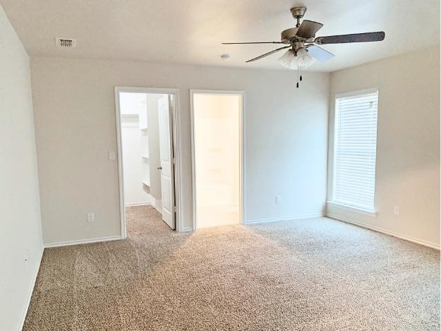 empty room featuring light carpet and ceiling fan