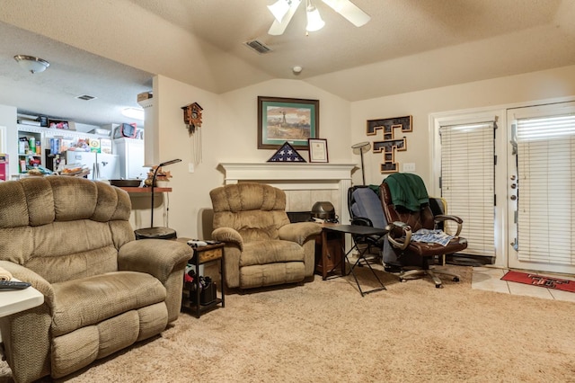 carpeted living room featuring ceiling fan, lofted ceiling, and a textured ceiling