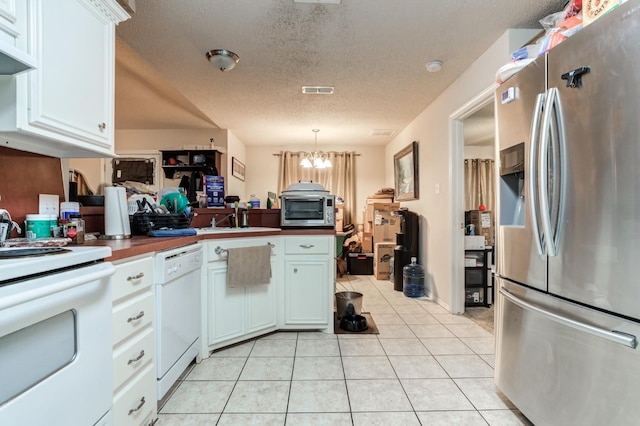 kitchen with pendant lighting, white appliances, light tile patterned flooring, and white cabinets