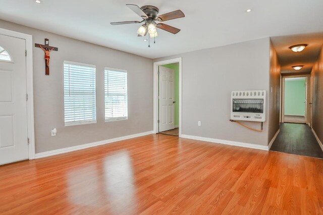 interior space featuring heating unit, ceiling fan, and light hardwood / wood-style flooring