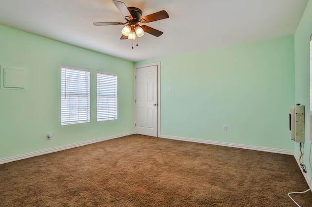 spare room with ceiling fan and dark carpet