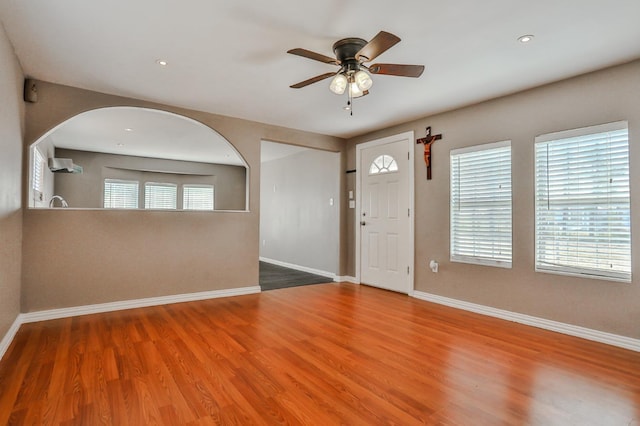 foyer entrance featuring wood-type flooring, ceiling fan, and plenty of natural light