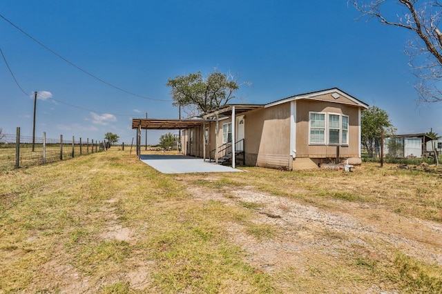 rear view of property featuring a carport and a yard