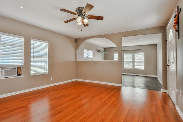 spare room featuring cooling unit, hardwood / wood-style floors, and ceiling fan