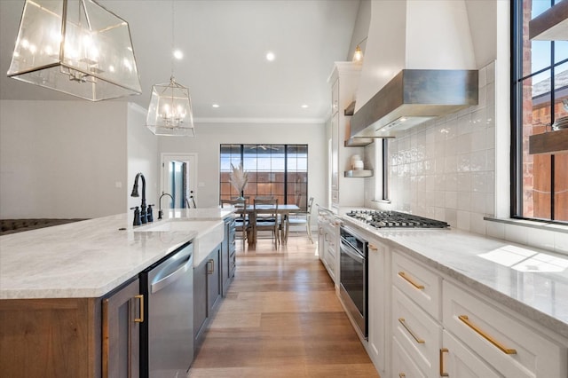 kitchen with white cabinetry, pendant lighting, stainless steel appliances, and island exhaust hood