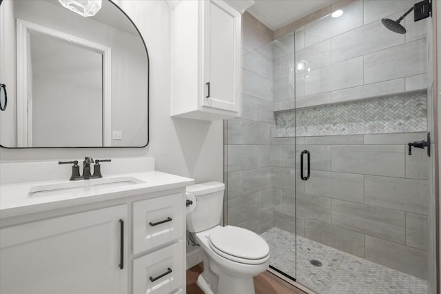 bathroom with walk in shower, vanity, and toilet