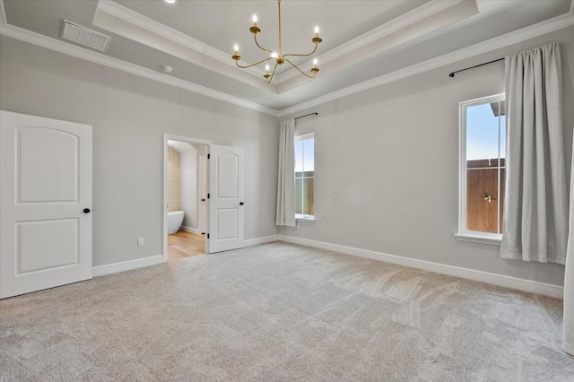 unfurnished bedroom featuring light colored carpet, ornamental molding, and a tray ceiling