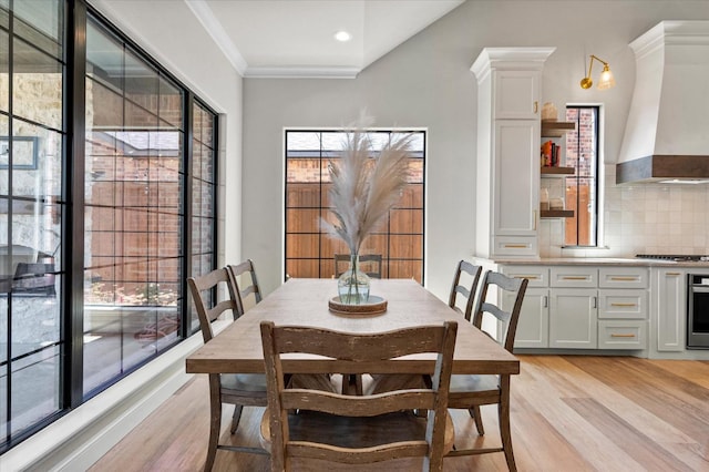 dining area with crown molding and light wood-type flooring