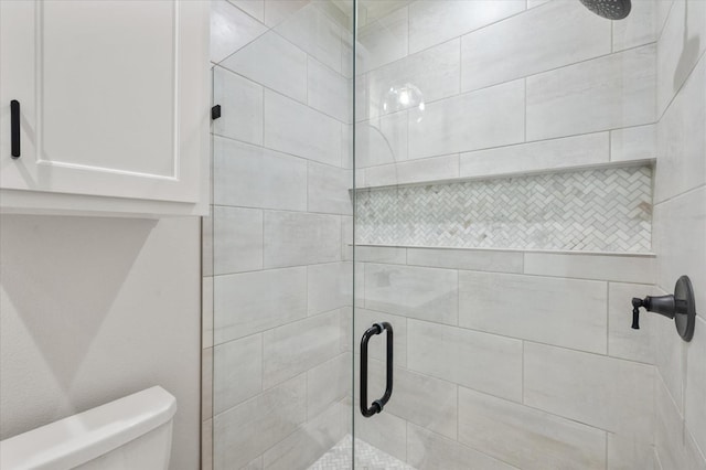 bathroom with toilet and a shower with shower door