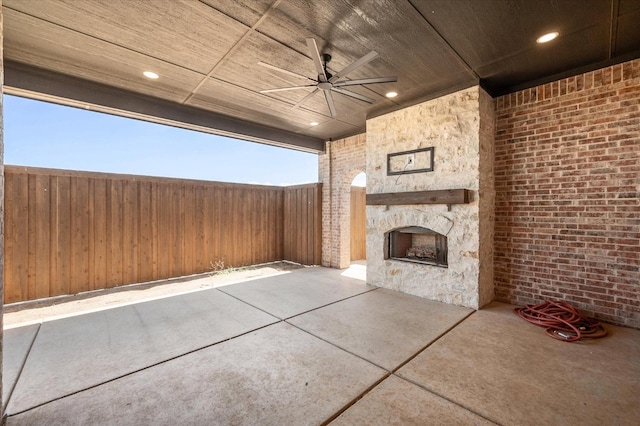 view of patio / terrace with ceiling fan and an outdoor stone fireplace