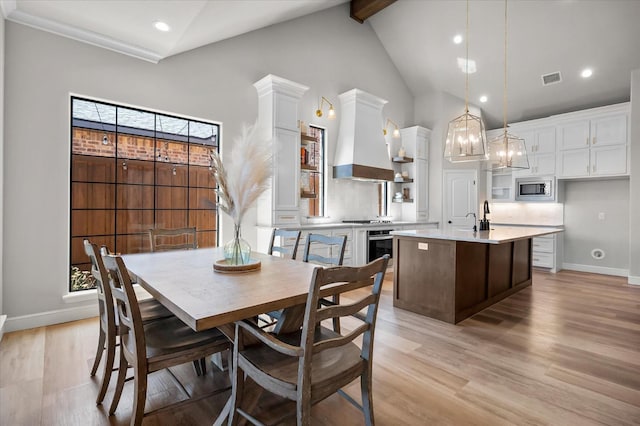 dining area with beam ceiling, a wealth of natural light, high vaulted ceiling, and light wood-type flooring