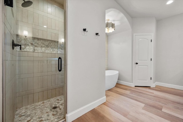 bathroom featuring wood-type flooring and separate shower and tub