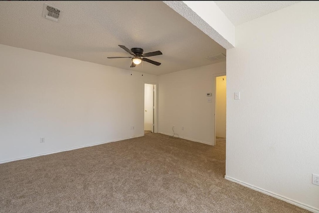 carpeted empty room featuring baseboards, a ceiling fan, and visible vents