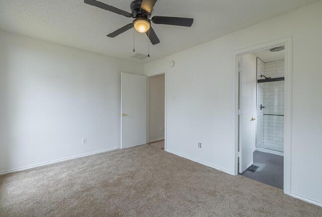 unfurnished bedroom featuring carpet flooring, ensuite bathroom, visible vents, baseboards, and ceiling fan