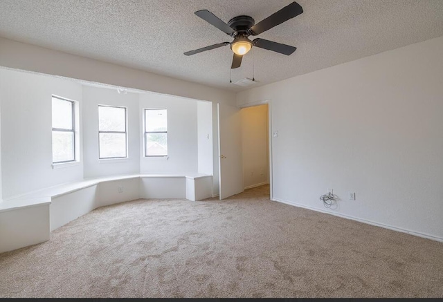 empty room featuring carpet floors, a textured ceiling, and ceiling fan