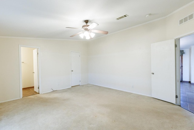 spare room featuring light carpet, ornamental molding, and ceiling fan