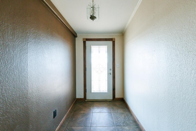 entryway with dark tile patterned flooring and crown molding