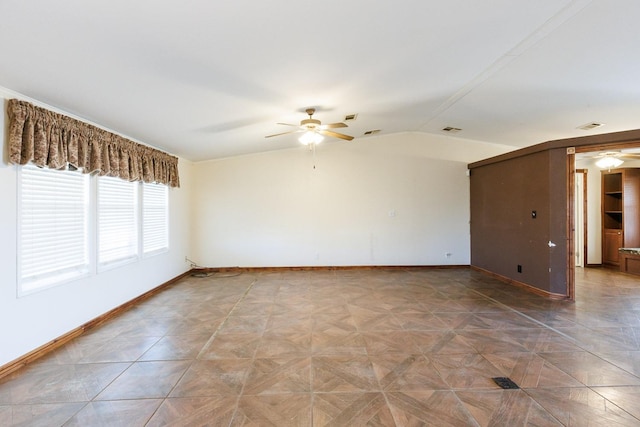 empty room featuring lofted ceiling, parquet flooring, and ceiling fan