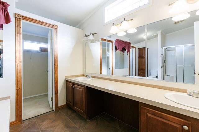 bathroom with vaulted ceiling, ornamental molding, vanity, and a shower with door