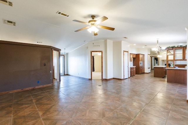 spare room featuring ceiling fan with notable chandelier, parquet flooring, and vaulted ceiling