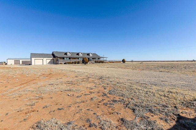 view of yard with a garage and a rural view