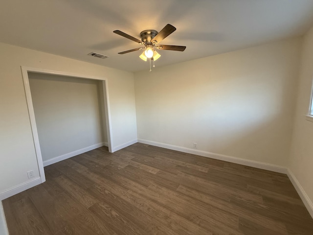 unfurnished bedroom with visible vents, baseboards, a ceiling fan, dark wood-style flooring, and a closet