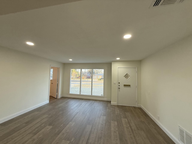 interior space featuring baseboards, visible vents, and dark wood-type flooring