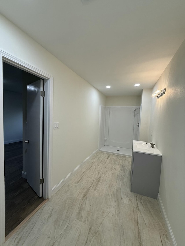 interior space with baseboards, a sink, and recessed lighting